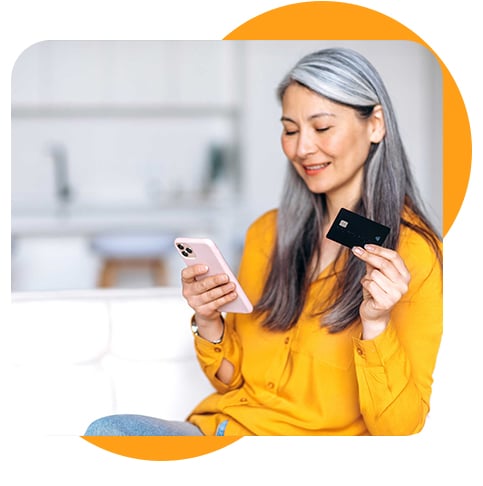 Woman holding a smartphone and holding a credit card