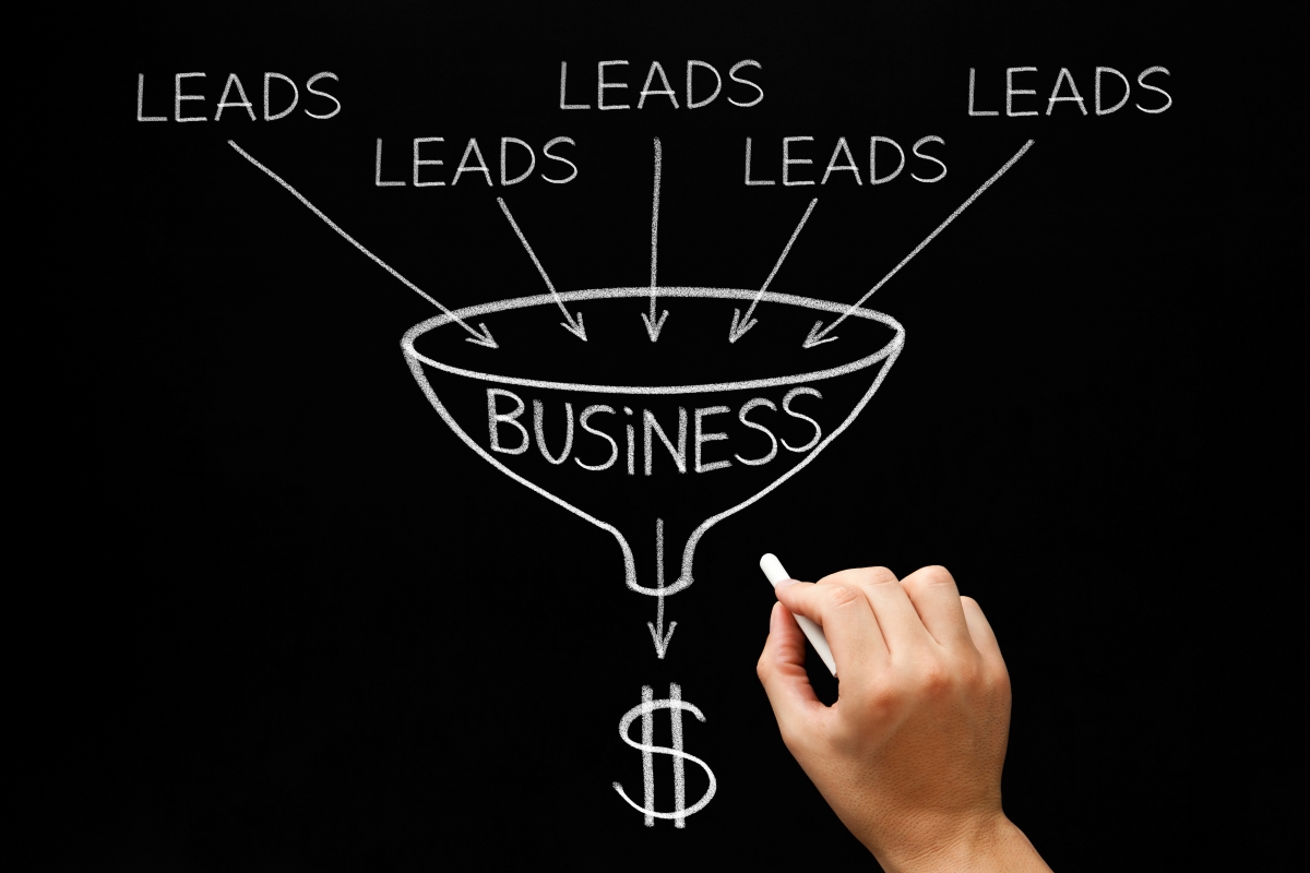 Person drawing funnel on chaulk board with words business and leads.