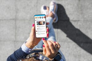 Top view of person using phone on social media.
