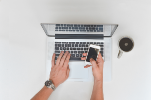 Top view of person using laptop and phone