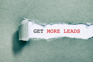 A green paper torn in the middle, revealing the words "GET MORE LEADS" in bold black and red text underneath.