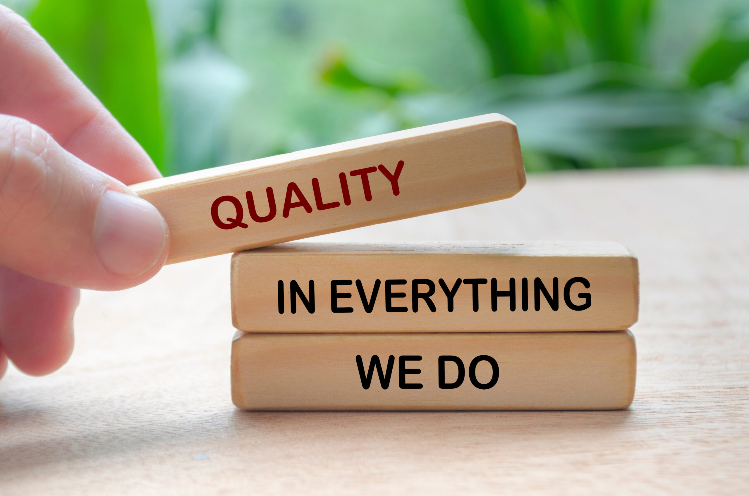 Quality in everything we do text on wooden blocks. Business quality concept.