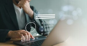 Business professional working on a laptop with clock and to do list interface, time management and productivity tools.
