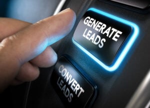 Hand about to press a generate leads button with blue light over black background.