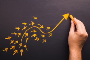 Hand draw a curve arrow leader with many small follower on chalkboard.