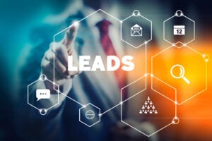 A businessperson points forward while digital hexagon icons surround the word “LEADS.” Icons include email, calendar, search, chat, and network symbols, representing interconnected lead channels and data-driven marketing systems.