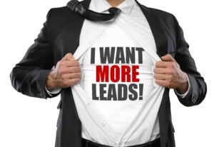 Man holding suit showing white shirt with words: I WANT MORE LEADS.