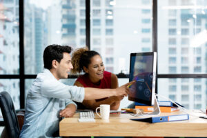 Man and woman working on laptop.