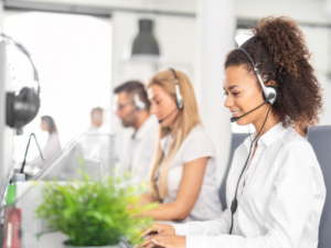 Group of people sitting next to each other and talking with headphones, representing telemartketers.
