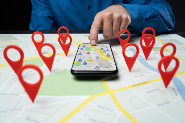 Phone on map with locations emojis.